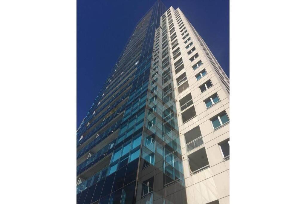 un edificio alto con ventanas de cristal en el lateral. en Hermoso departamento en la torre Palermo UNO. en Buenos Aires