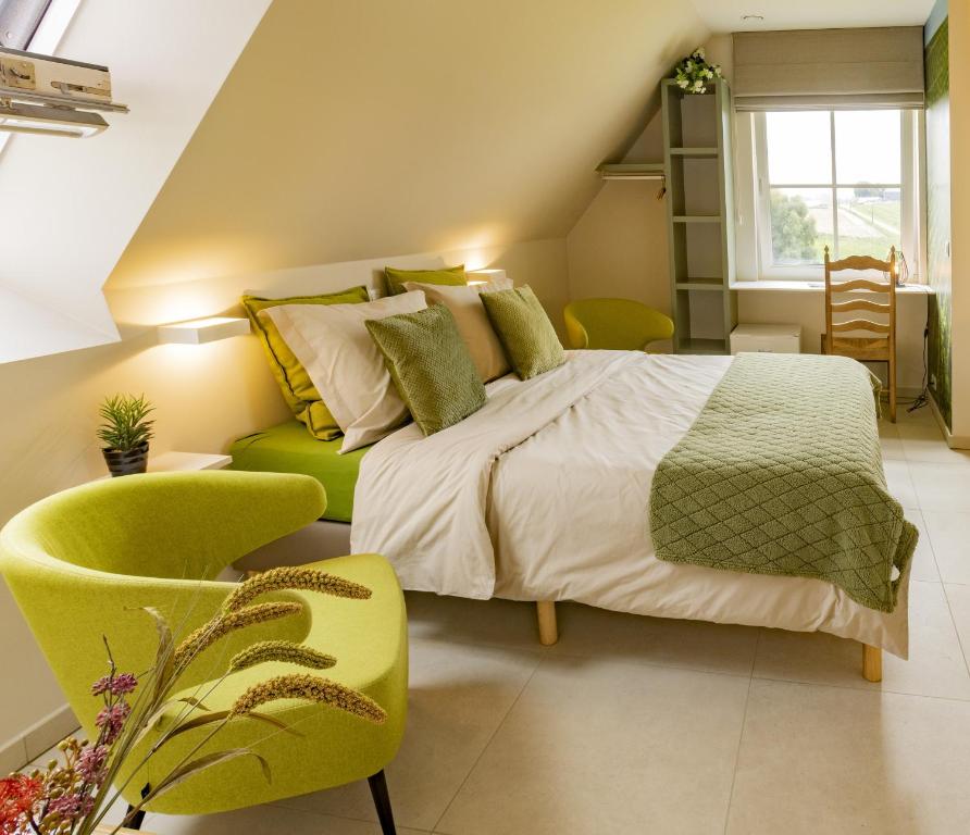 1 dormitorio con 1 cama grande y 1 silla amarilla en B&B De Zavelaar, en Heuvelland