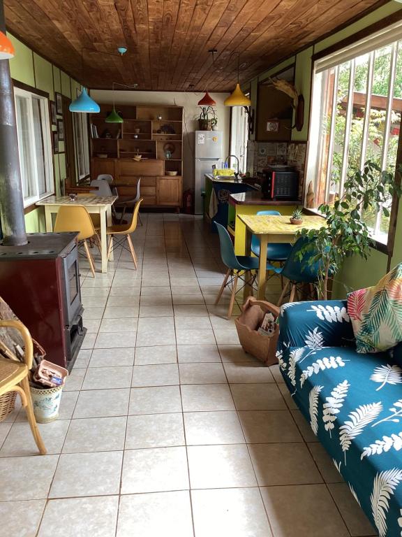 Cabaña la Solar. في فروتيلار: مطبخ وغرفة معيشة مع أريكة وطاولة