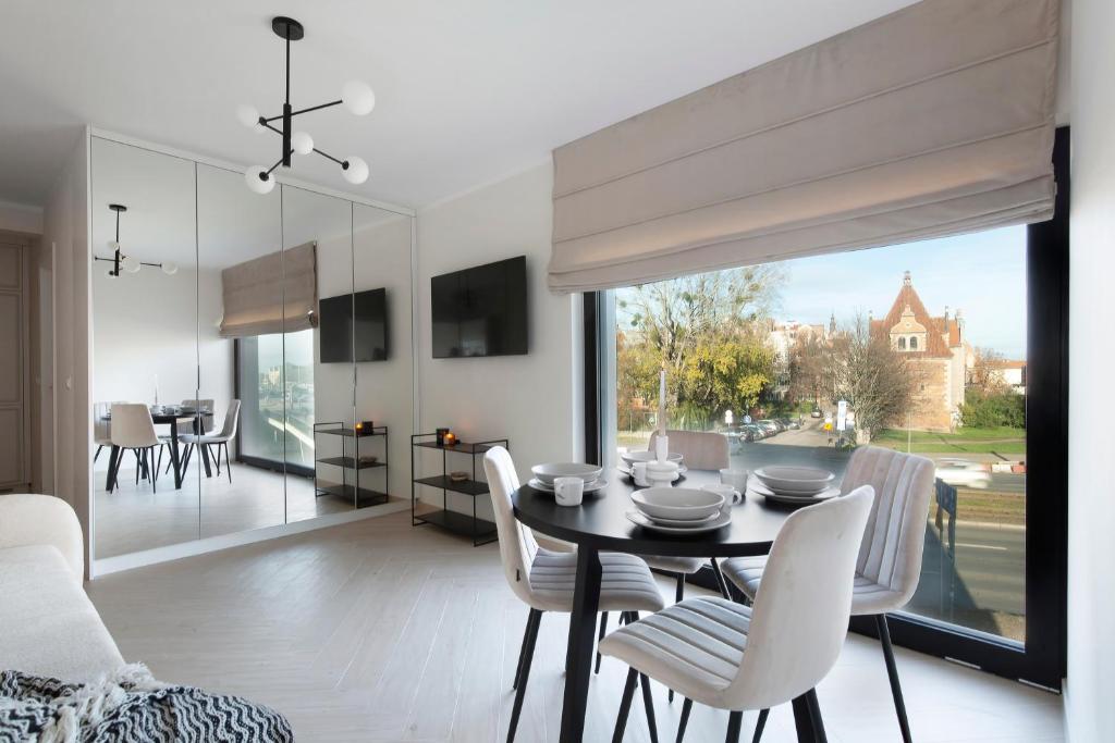 a dining room and living room with a table and chairs at Elite Apartments Rezydencja Wintera in Gdańsk