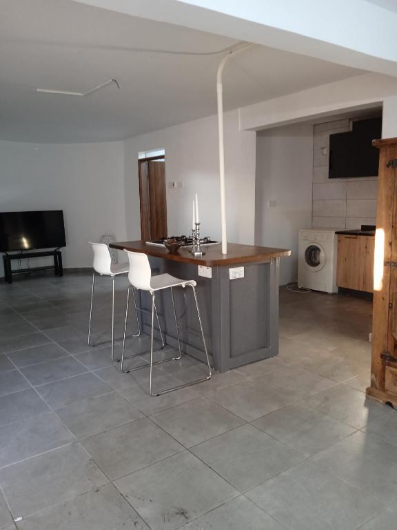 a kitchen with a table and chairs in a room at Large basement home in Kolossi