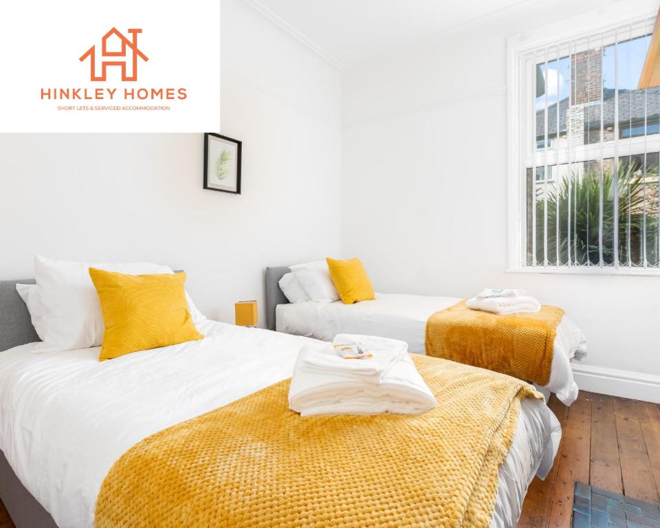 duas camas num quarto com amarelo e branco em Supersized 5bed - Free parking - 8 beds - Anfield - By Hinkley Homes Short Lets & Serviced Accommodation em Liverpool