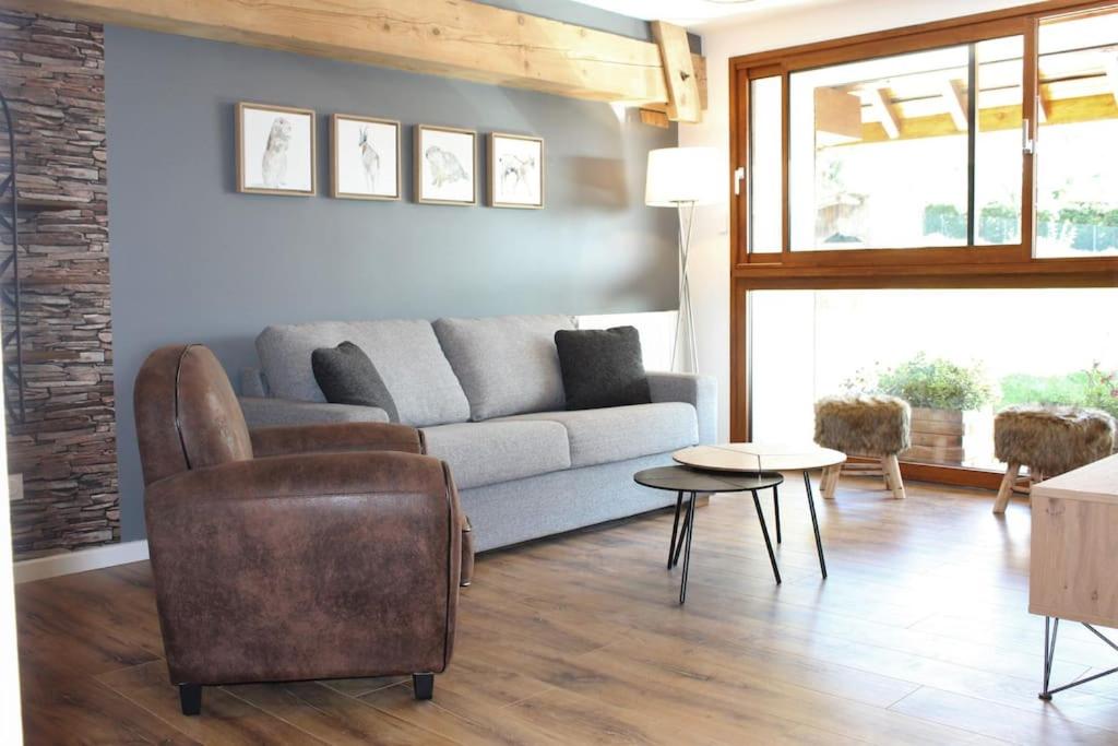 uma sala de estar com um sofá e uma mesa em T4 Meublé de 105m2 axe Annecy-Geneve em Saint-Martin-Bellevue
