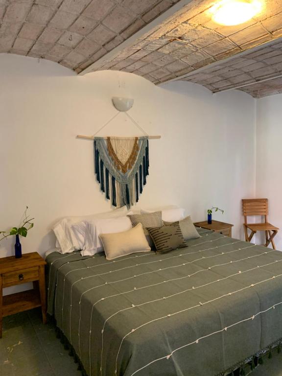 a bedroom with a large green bed in a room at Oka Hey, Sayulita in Sayulita
