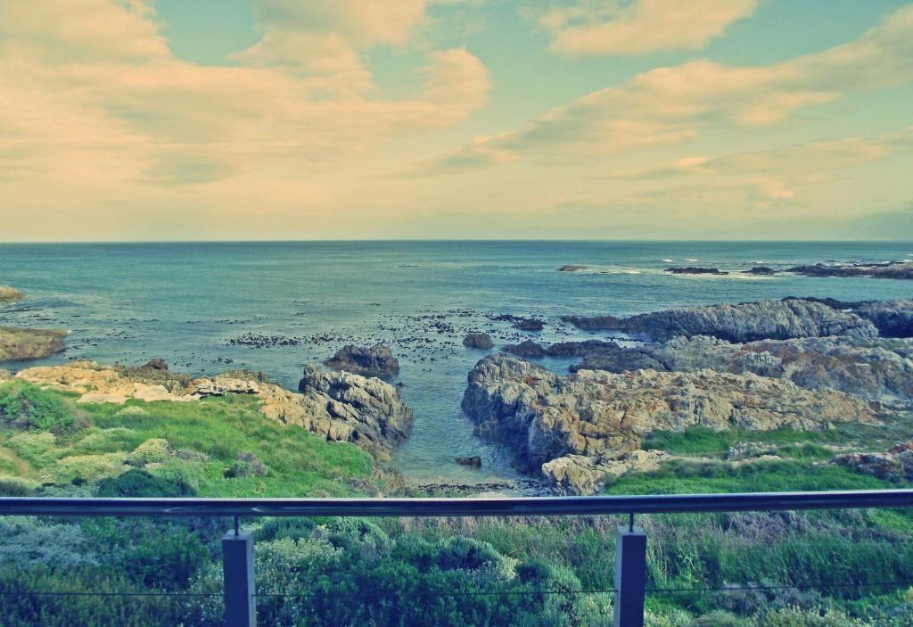 a view of the ocean with rocks in the water at Waterside Apartment in Gansbaai