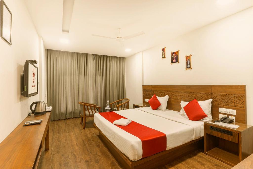 a hotel room with a bed and a desk at KINGS CALICUT in Kozhikode