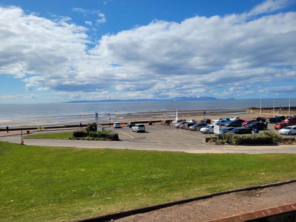 a parking lot next to the beach with cars parked at Links Quay 42 in Prestwick