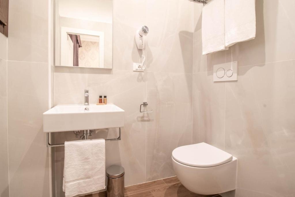 a white bathroom with a sink and a toilet at DANY GUEST HOUSE in Rome
