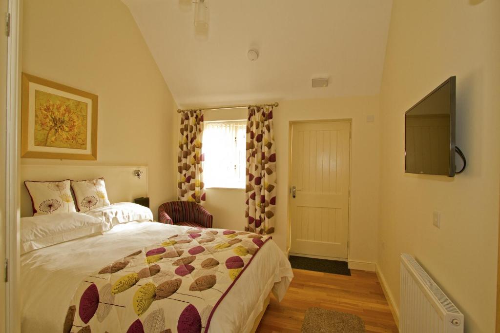 a bedroom with a bed and a television in it at Meals Farm - Courtyard Room in North Somercotes