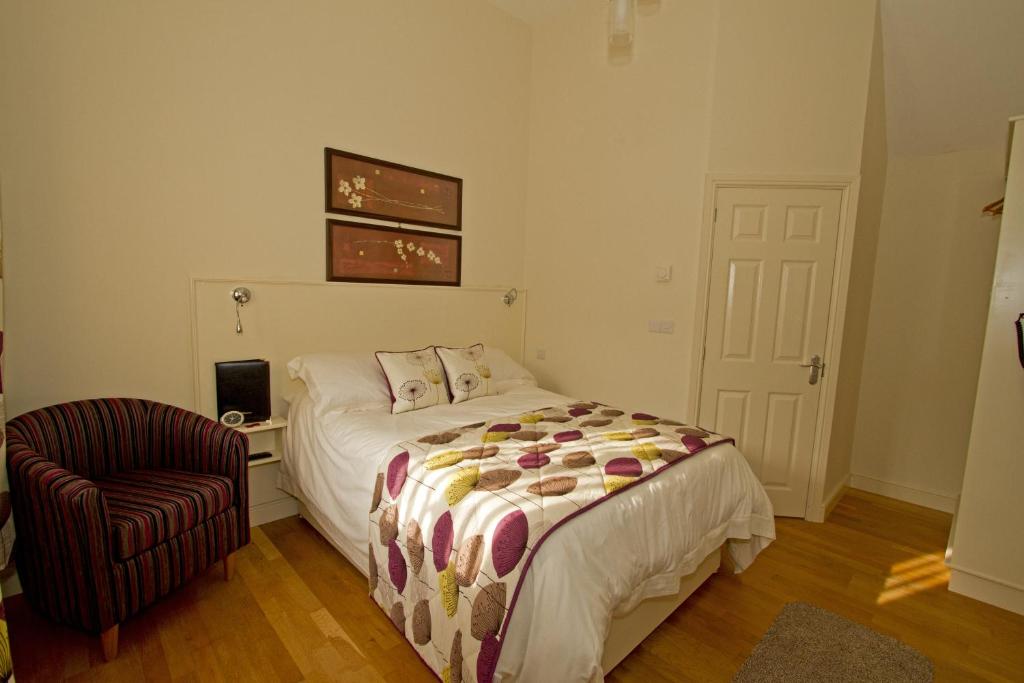 a bedroom with a bed and a chair at Meals Farm - Courtyard Room in North Somercotes