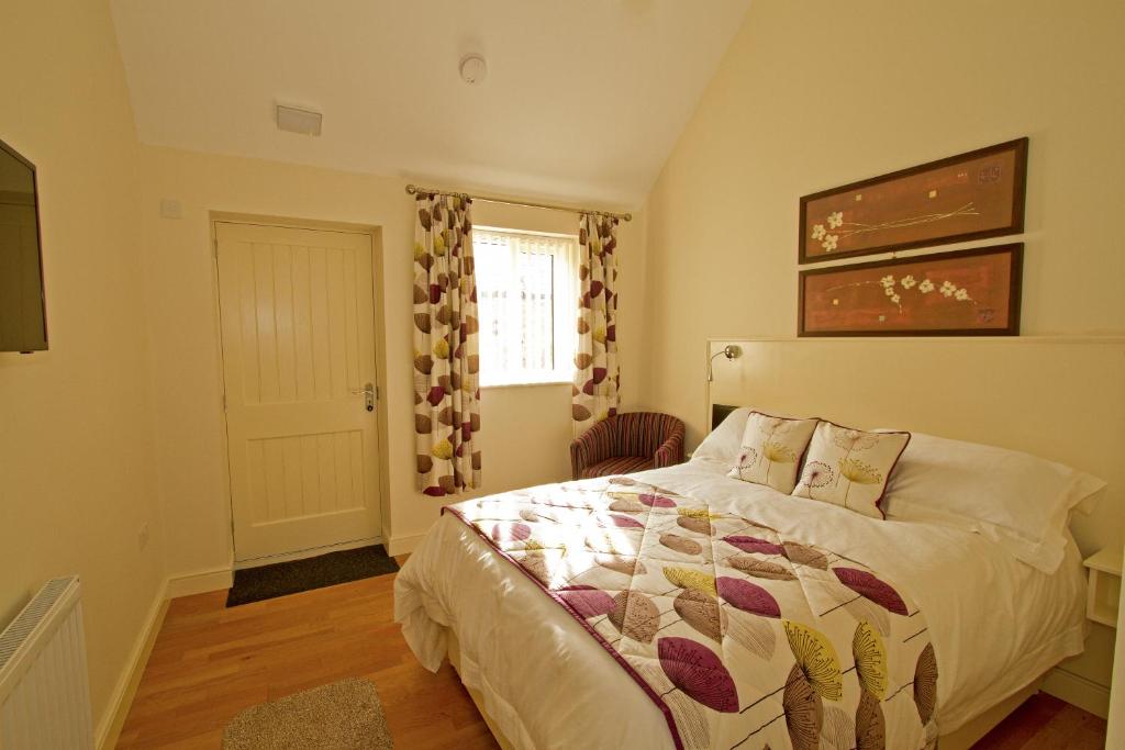 a bedroom with a bed and a window at Meals Farm - Courtyard Room in North Somercotes