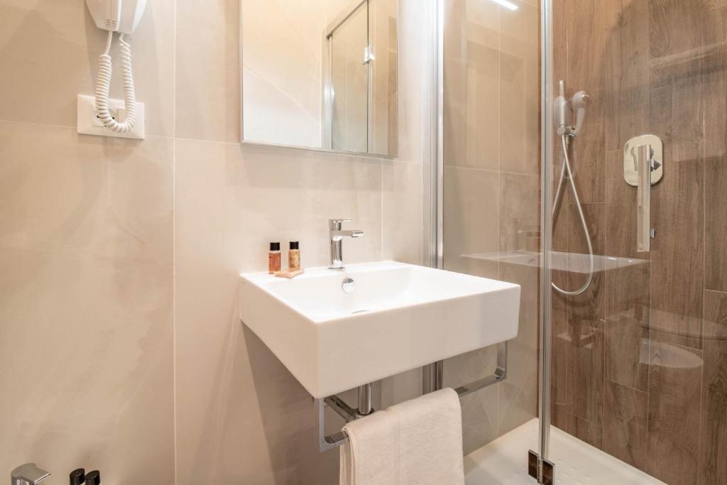 a white bathroom with a sink and a shower at DANY GUEST HOUSE in Rome