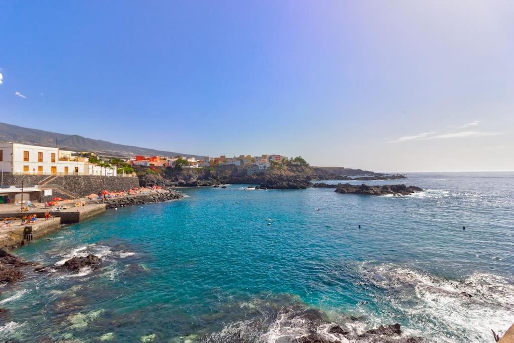 Blick auf einen Strand mit blauem Wasser und Gebäuden in der Unterkunft Acogedor apartamento en Alcalá - By Feel your holidays in Alcalá