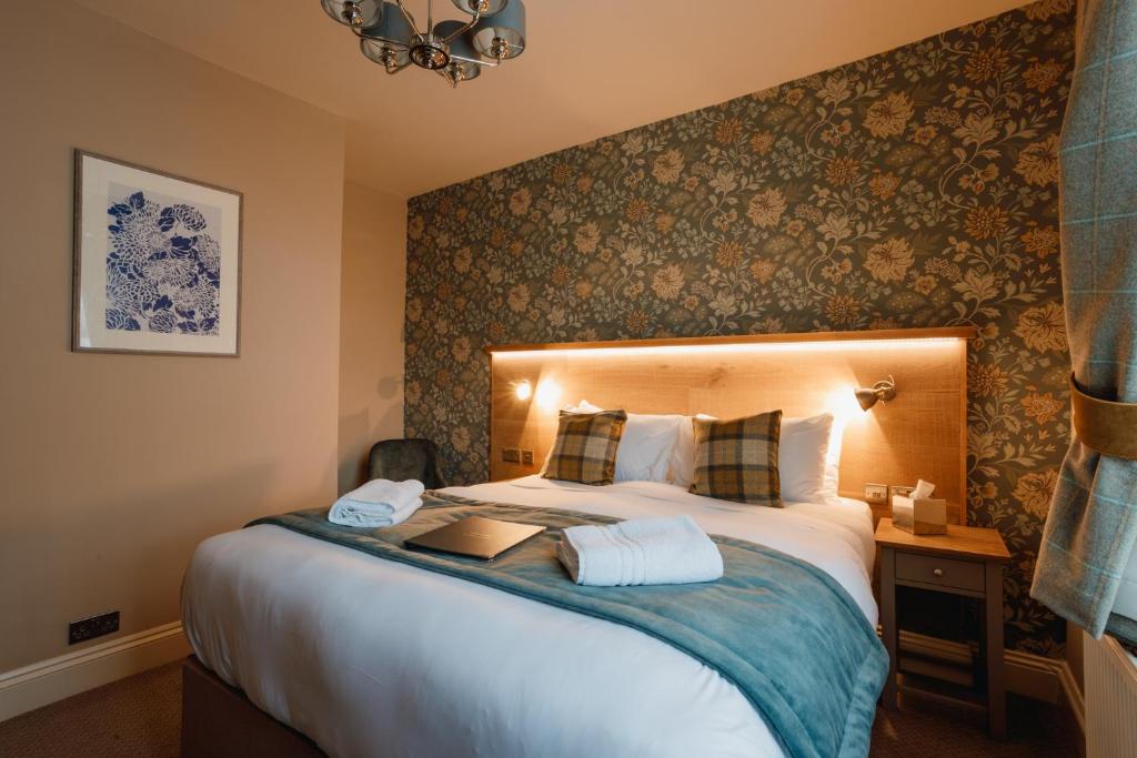 a hotel room with a bed with a book on it at The Bell in Solihull