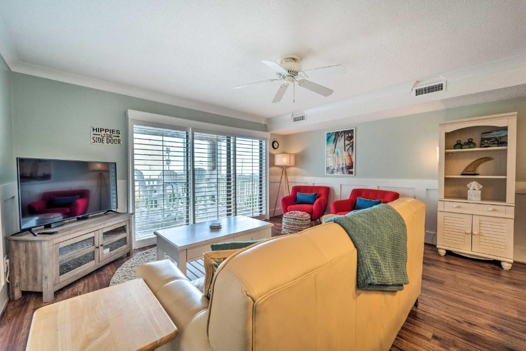a living room with a couch and a tv at Bright Carolina Beach Condo - Walk to Shore! in Carolina Beach
