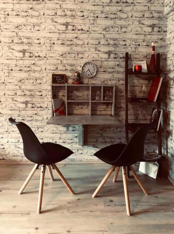 Habitación con 2 sillas y reloj en una pared de ladrillo en Cozy Apartment Fremersberg for 2, en Baden-Baden