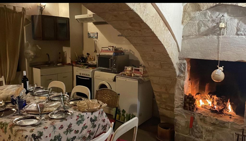 kuchnia ze stołem i kominkiem w pokoju w obiekcie Via vecchia dei postriboli w mieście Bisceglie