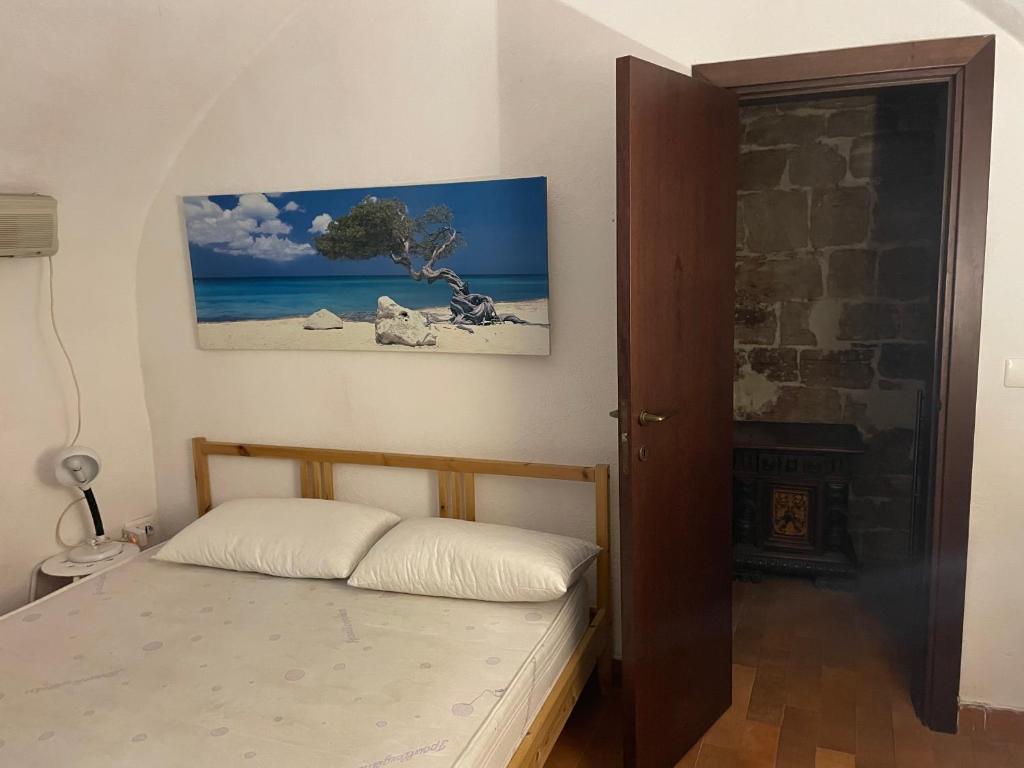 1 dormitorio con 1 cama y una pintura en la pared en Via vecchia dei postriboli, en Bisceglie