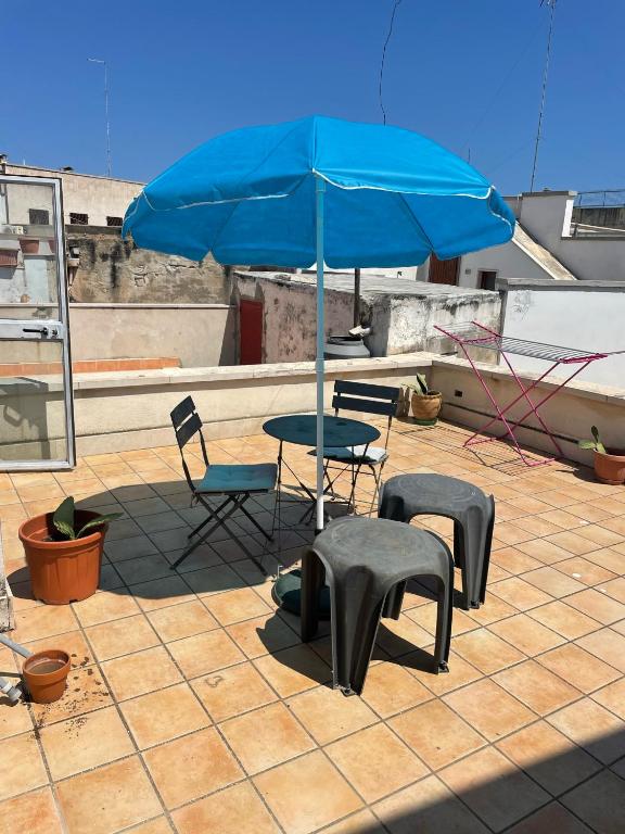 stół, krzesła i parasol na dachu w obiekcie Via vecchia dei postriboli w mieście Bisceglie