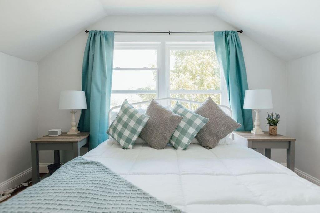 a bedroom with a bed with blue curtains and a window at Charming Apt with chic decor Superhost w 5 Stars in Bristol