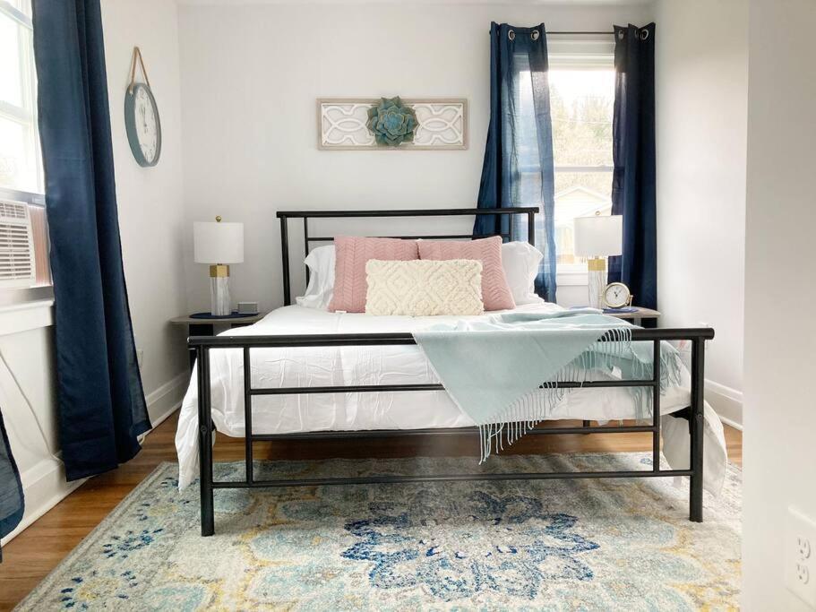 a bedroom with a bed with pink pillows on it at The Rustic Retreat- close to downtown in Bristol