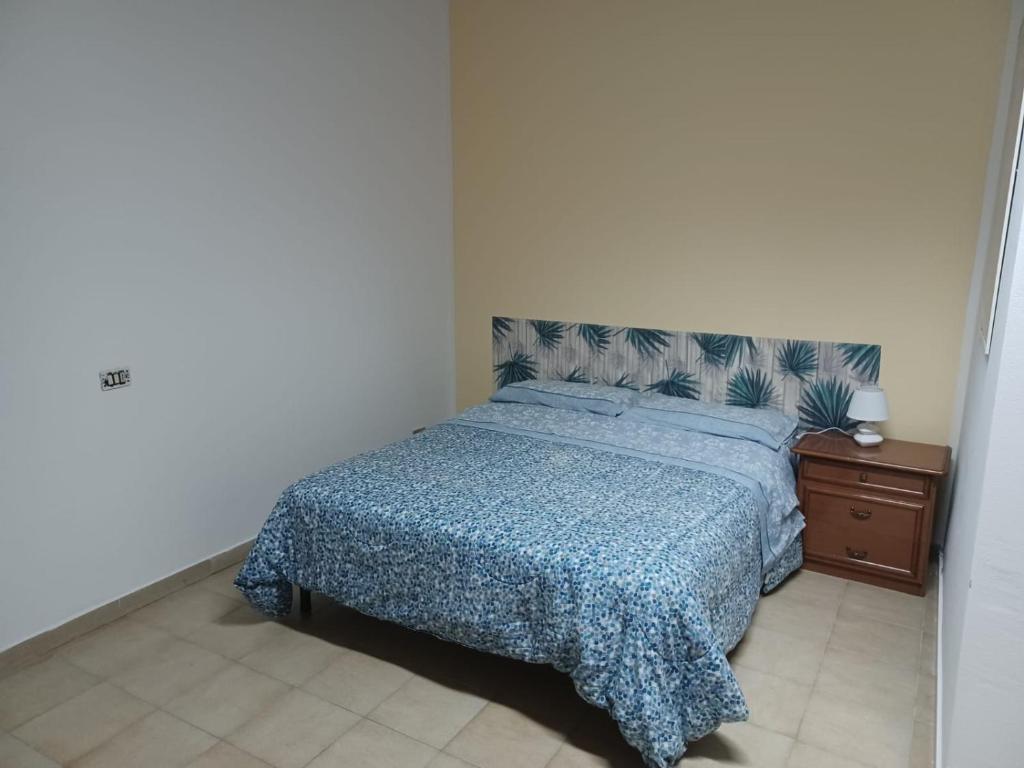 1 dormitorio con 1 cama con edredón azul en Giovanna 199, en Rende