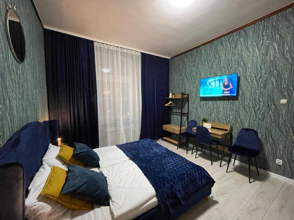 a bedroom with a bed and a desk and a tv at Great Polonia Wrocław Tumski in Wrocław