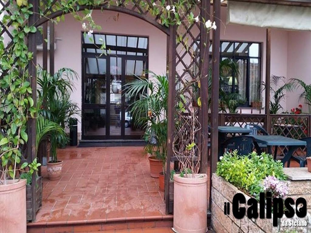 an entrance to a patio with potted plants at Hotel Ristorante Il Calipso by Mago in Robecchetto con Induno