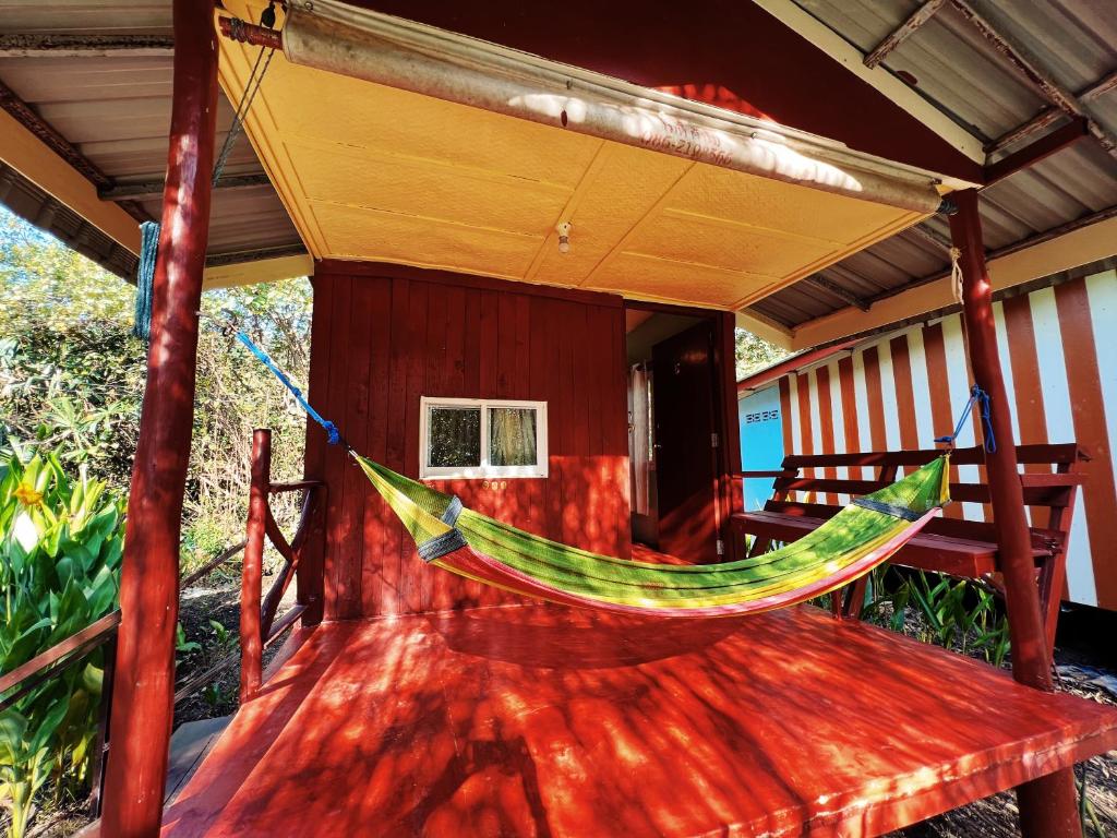 a hammock on the porch of a house at LONELY GROOVE in Ko Chang