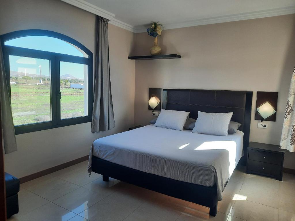 een slaapkamer met een bed en een groot raam bij Riviera Park Apartamento 2A in Puerto del Carmen