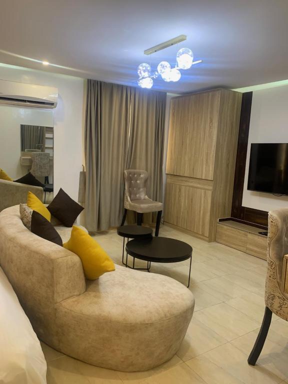 uma sala de estar com um sofá e uma televisão em YP George em Lekki