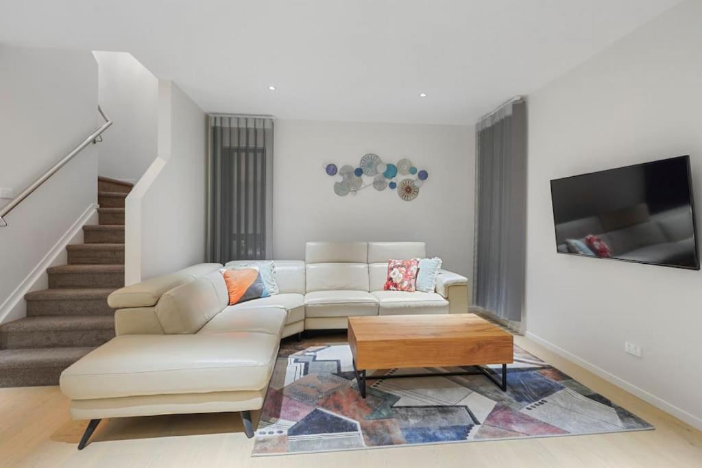 a living room with a couch and a coffee table at Nexus Townhouse with Parking and Wi-Fi in Auckland