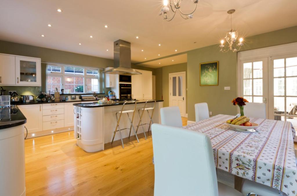 a kitchen and living room with a table and a kitchen and a dining room at Leafy Suburban Bed and Breakfast in Northwood