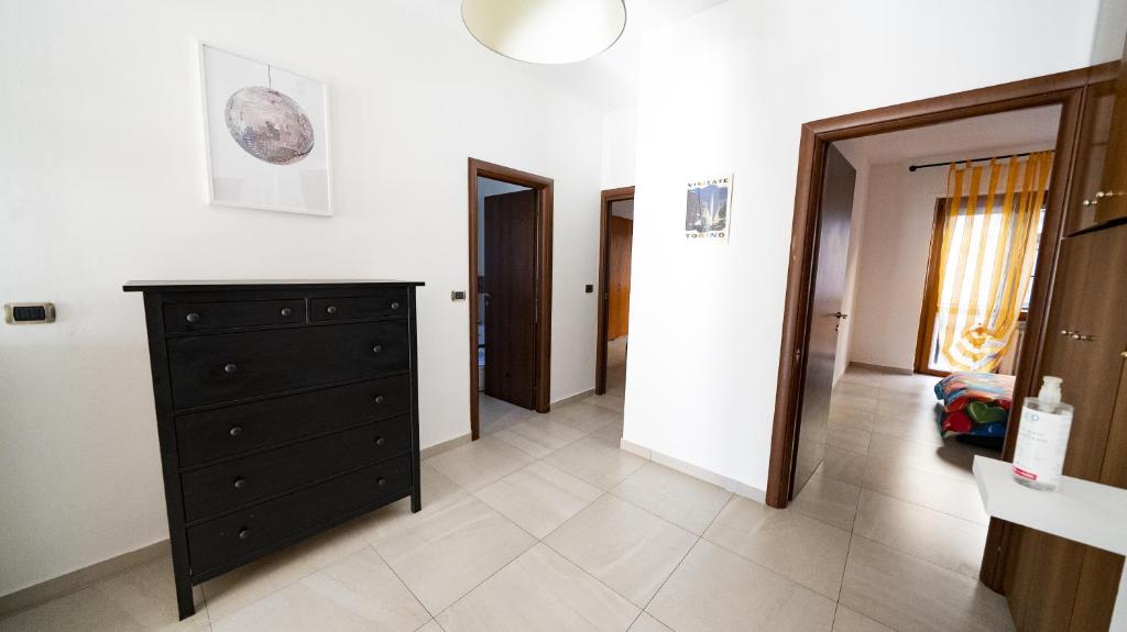 ein Wohnzimmer mit schwarzer Kommode und Flur in der Unterkunft DORA Rooms and terrace, Parco Dora in Turin