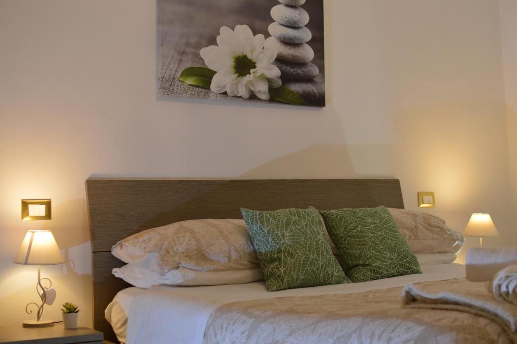 um quarto com uma cama com almofadas verdes e brancas em Pacific House em Foligno