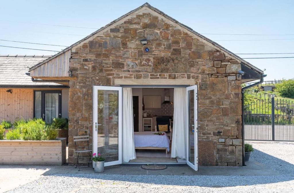 a small stone building with a bed in it at Rossendale Holiday Cottages & Spa in Rossendale