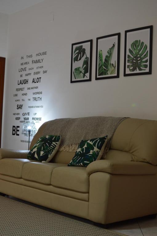 kanapę w salonie z czterema zdjęciami na ścianie w obiekcie Pacific House w mieście Foligno