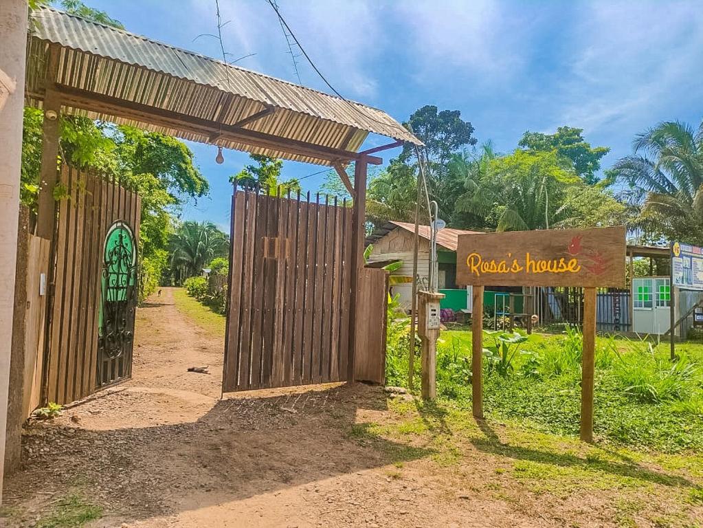 a gate with a sign in front of a house at ROSA'S HOUSE in Puerto Maldonado