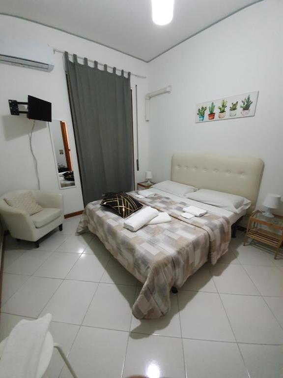 a bedroom with two beds and a chair in it at Alba central City in Palermo