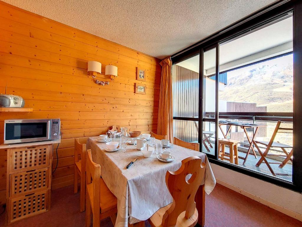 une salle à manger avec une table et une grande fenêtre dans l'établissement Bel Appartement aux Pistes, 6 Pers., Balcon - FR-1-344-400, aux Menuires