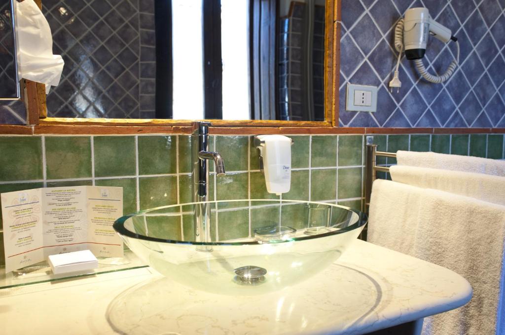 a bathroom sink with a glass bowl on a counter at Nascar Hotel in Santa Maria Navarrese