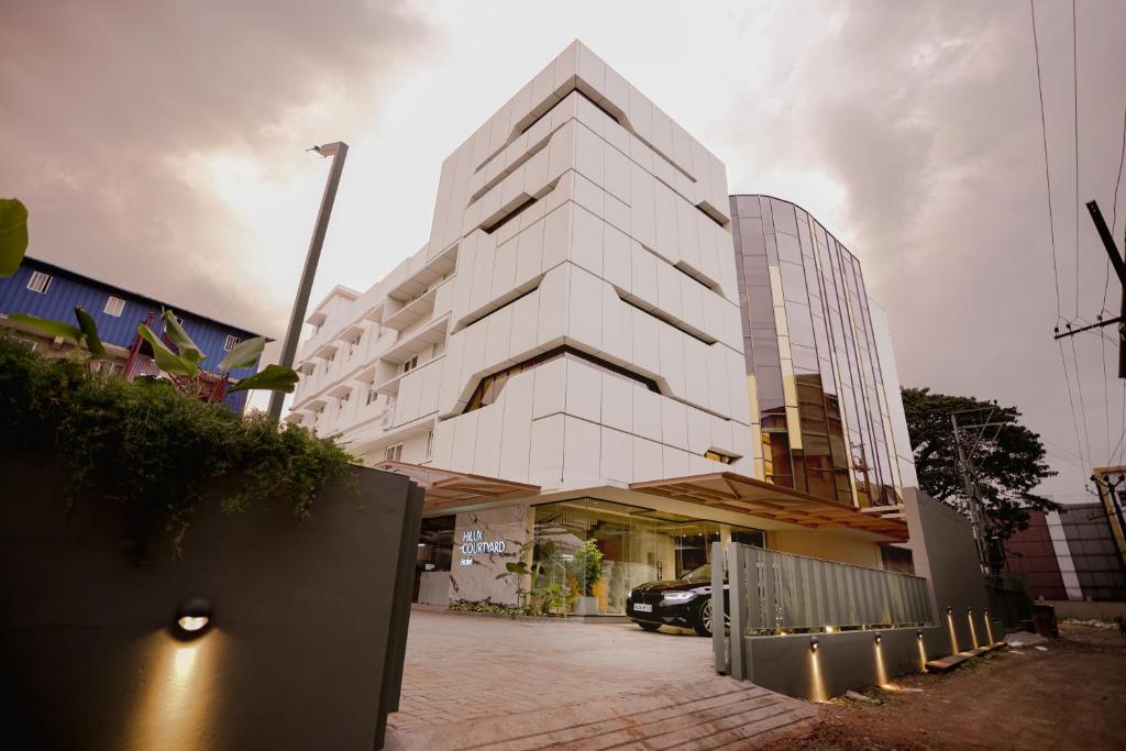 un edificio blanco con una valla delante en HILUX COURTYARD, en Palakkad