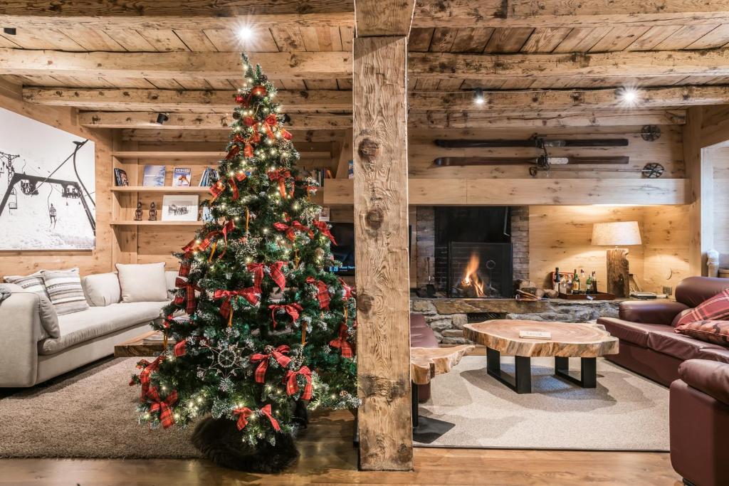 a christmas tree in a living room with a fireplace at Casa Pleta de Baqueira Deluxe by Totiaran in Naut Aran