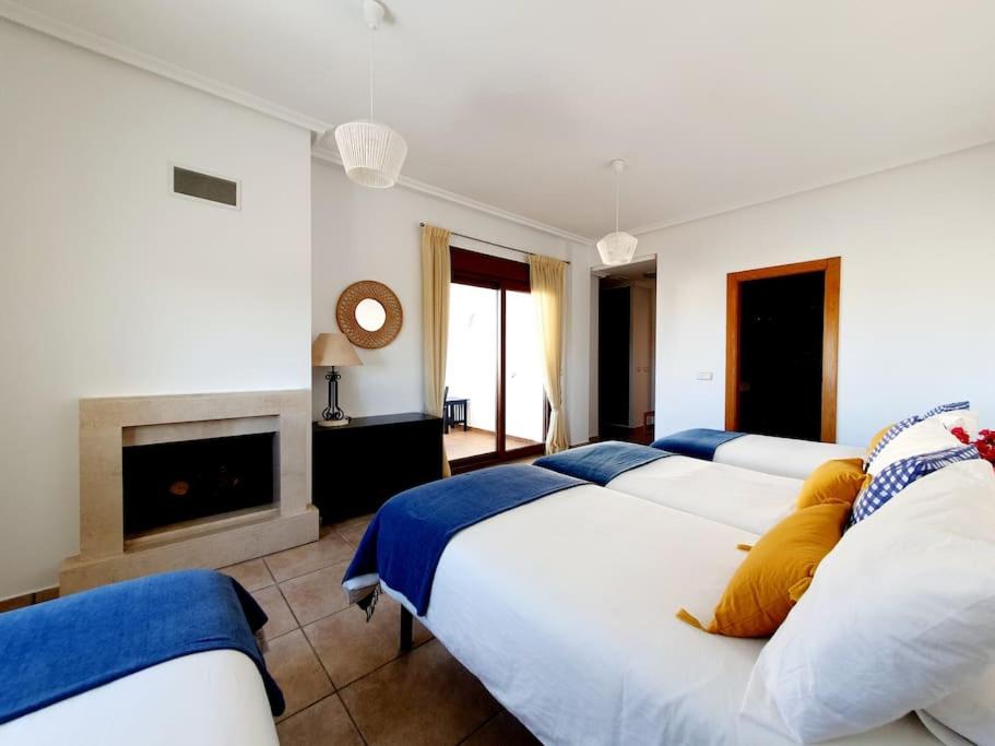 1 Schlafzimmer mit 3 Betten und einem Kamin in der Unterkunft Villa Jacaranda Altaona Golf in Murcia