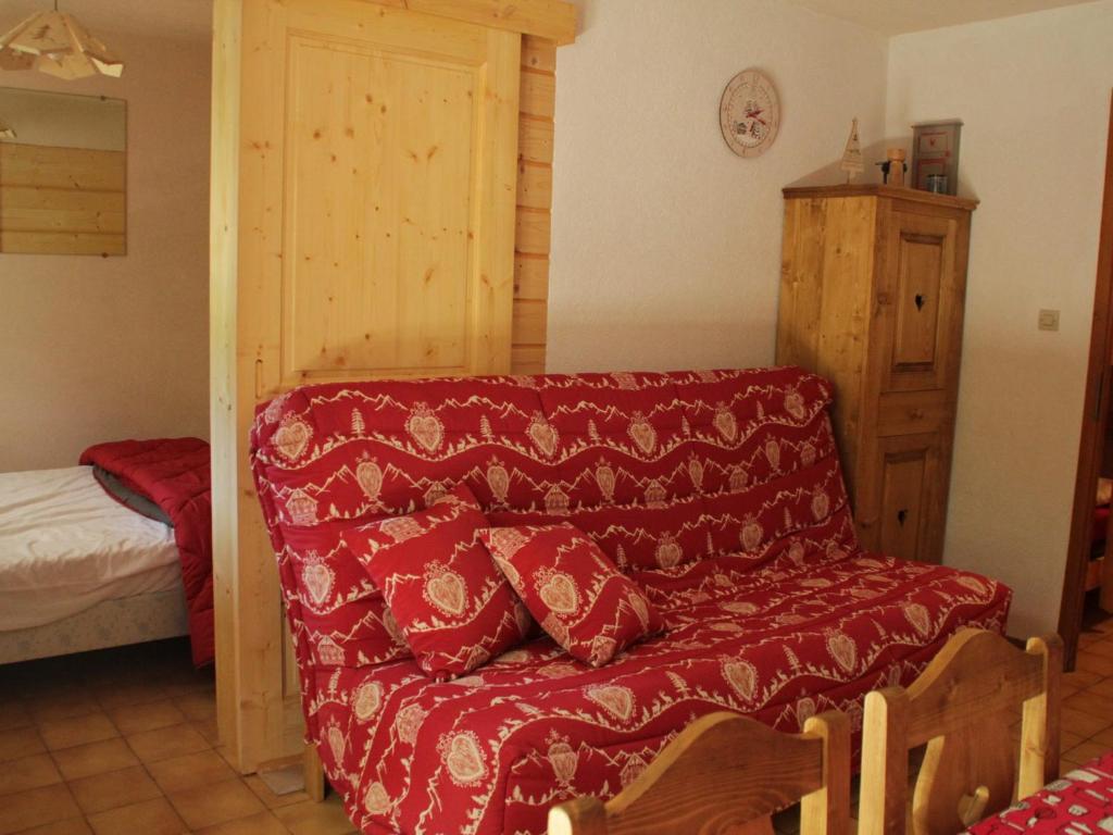 シャテルにあるAppartement Châtel, 1 pièce, 4 personnes - FR-1-200-188のリビングルーム(赤いソファ、ベッド付)