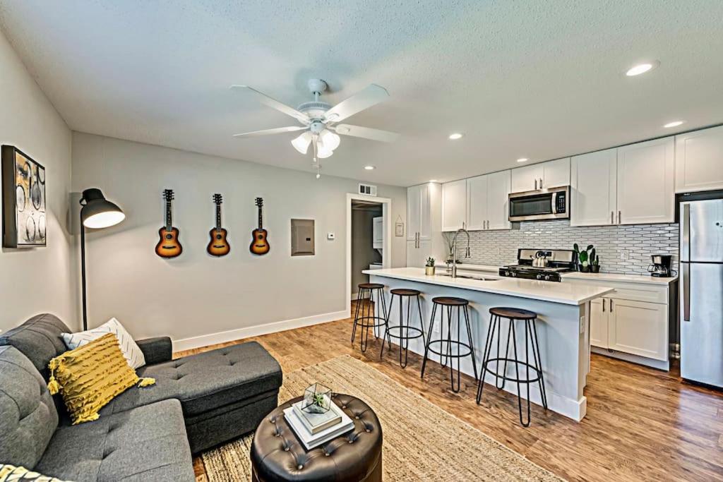 a living room with a couch and a kitchen at The Rhythm Room Near Downtown Dallas! in Dallas