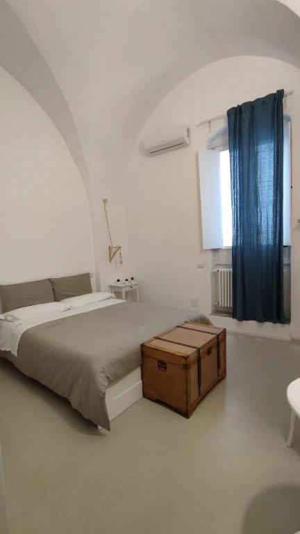 una camera bianca con letto e tenda blu di B&b Sedilequattro a Castellaneta