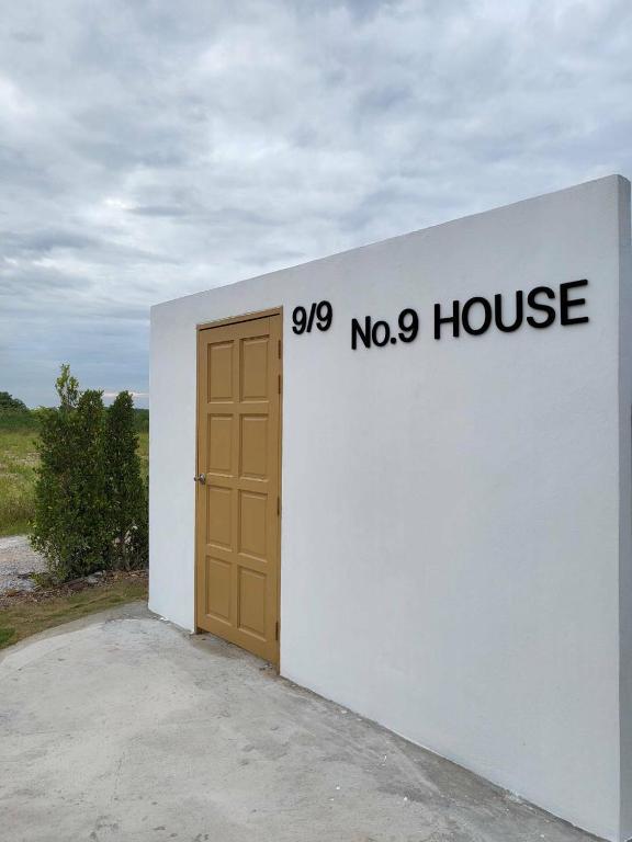 ein weißes Gebäude mit Tür und ohne Haus in der Unterkunft No 9 HOUSE Hua Hin in Khao Tao