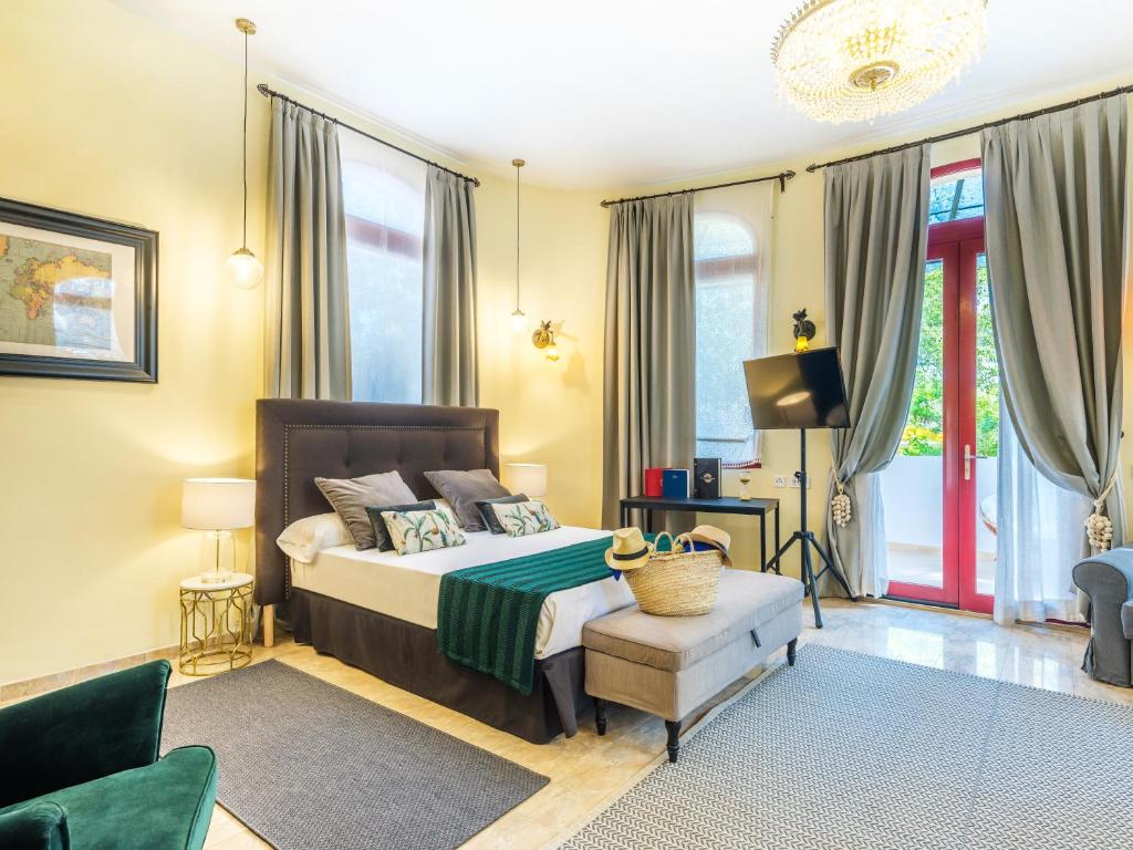 a bedroom with a bed and a chair and windows at Hotel Ciutat Jardi in Palma de Mallorca