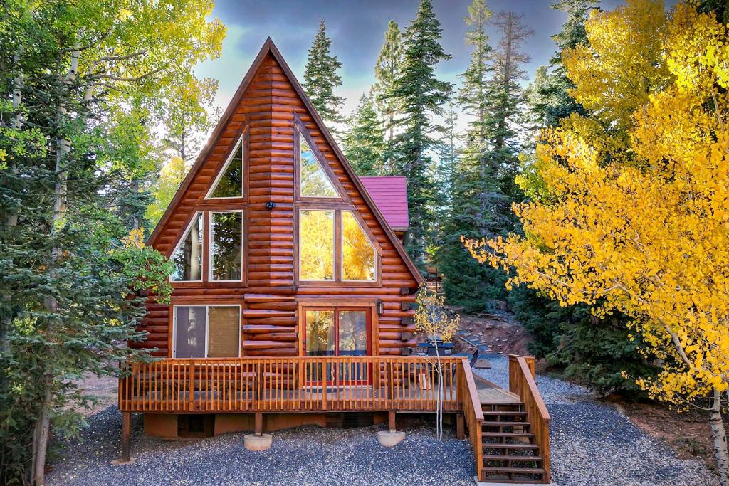 a cabin in the woods with a large window at A-Frame Cabin Near Hiking and Biking Trails! in Duck Creek Village